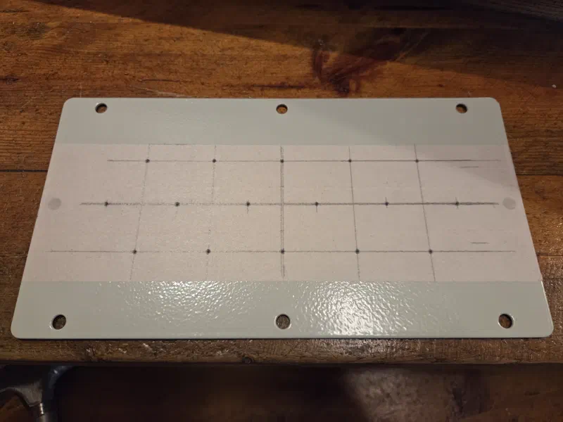 Marking out hole layout and center punching the gland plate for drilling