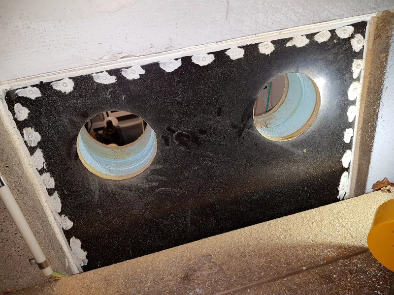 Two ventilation holes drilled through plywood and styrofoam
